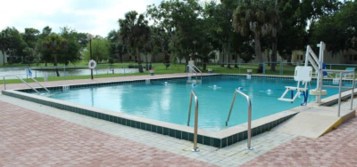 Bishop's Glen, community swimming pool with lift chair. A pond beyond the pool in the background.