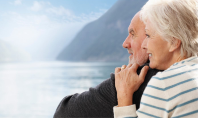 Florida Assisted Living Association. A man and woman embracing each other on the right with a mountain and water in the background and to the left.