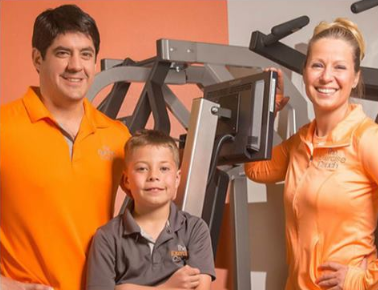 Franchise Business Review. A family poses for a photo in front of exercise equipment.