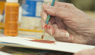 The Beacon at Gulf Breeze, a hand painting on canvas or paper with a paint bottle in the background.