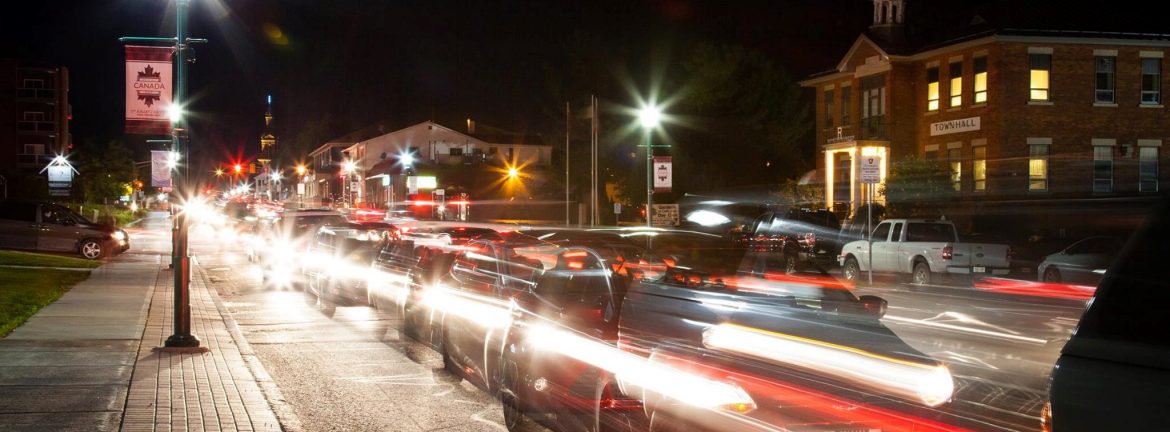 Clarence-Rockland, Ontario. A view of a city street at night with cars blurred in motion.