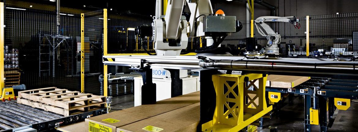 Columbia Machine Company, a large machine in a warehouse with boxes and pallets around.