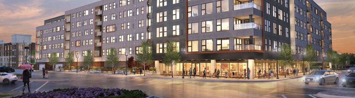 Elmhurst Illinois, the corner of the street showing a large multi story building with lights on and people walking outside.