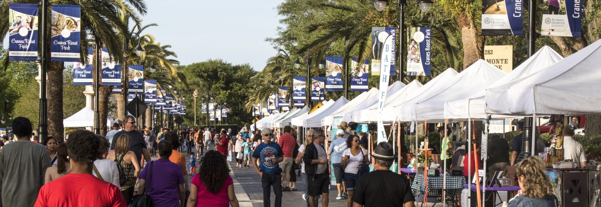 Altamont Springs, Florida event downtown with people walking down palm tree and vendor lined streets.