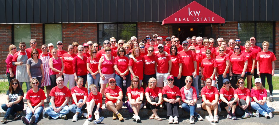 Keller Williams Realty Metropolitan. A group shot of employees out front of their office all in red Keller Williams Realty shirts.