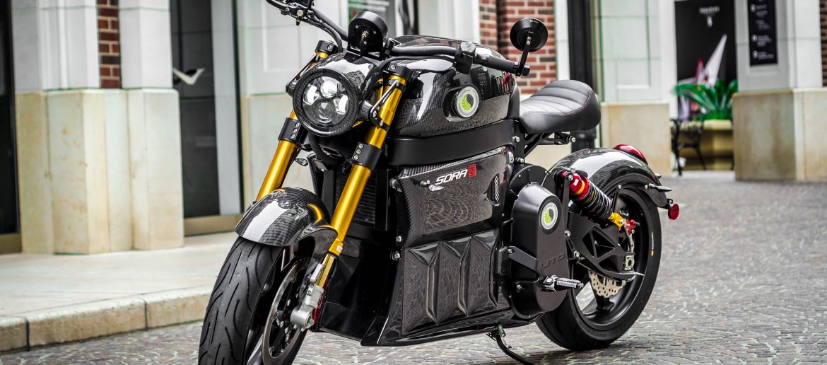 LITO, Sora Motorcycle sitting on a brick paved street without anyone on it.