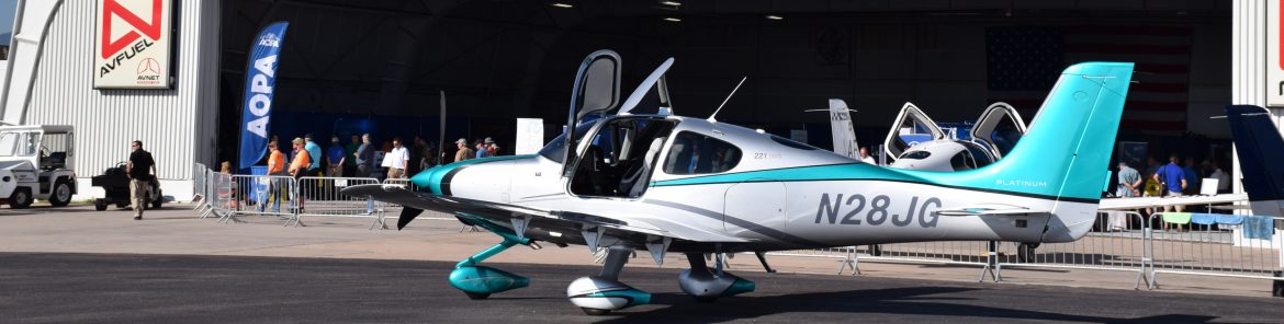 Colorado Springs Airport hangar for an event with single prop planes out front.