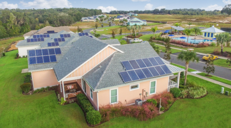An aerial view of a home with solar panels on the roof.