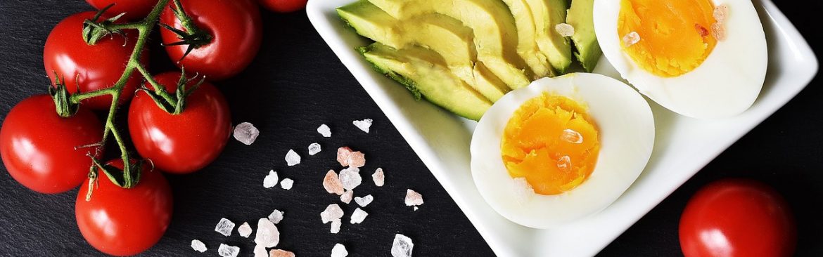Hubba feature image showing tomatoes on the vine next to a plate with sliced avacados and a hard boiled egg cut in half. Some rock salt sprinkled on the table in front of the plate and a little on the egg.