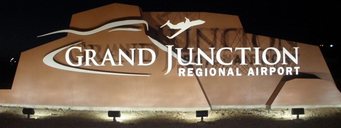 Grand Junction Regional Airport sign at night with lights shining on it.