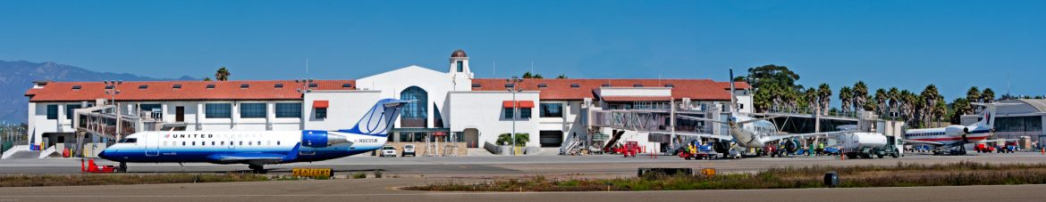 Santa Barbara Municipal Airport rampside view with jets pulled up and service vehicles nearby.