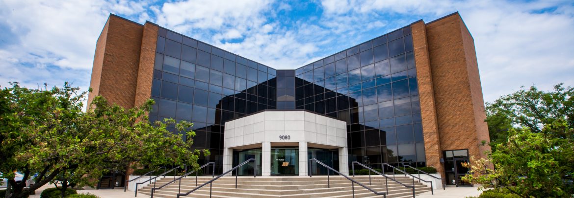 Michelman building front view with glass windows across the front facing walls and large steps out front.