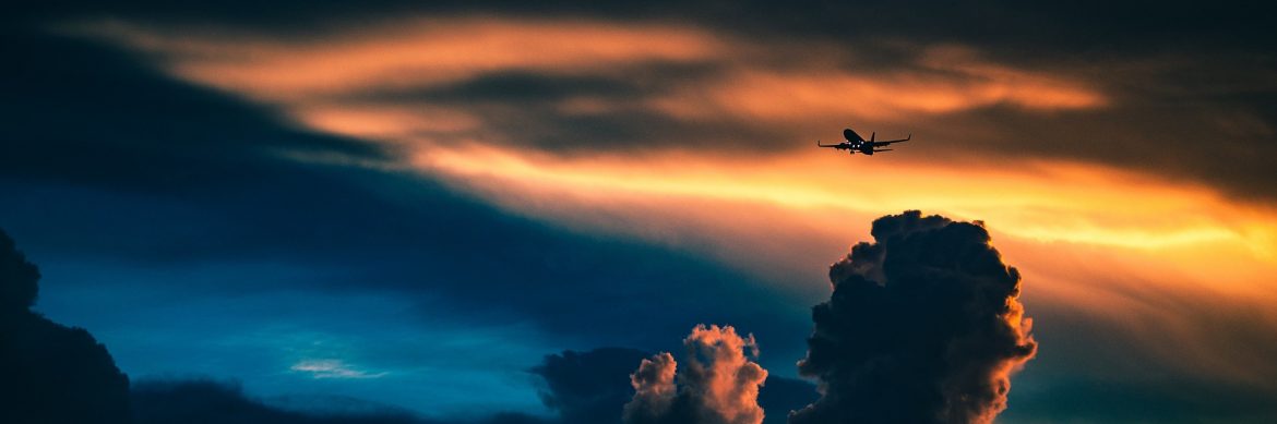 Cape Fear Regional Jetport, a jet flying with clouds and colorful skies.