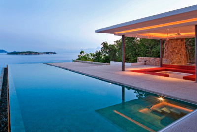 Latham Pool Products, view of their work showing a pool overlooking the ocean with a pool and pool house/covered area for sitting.