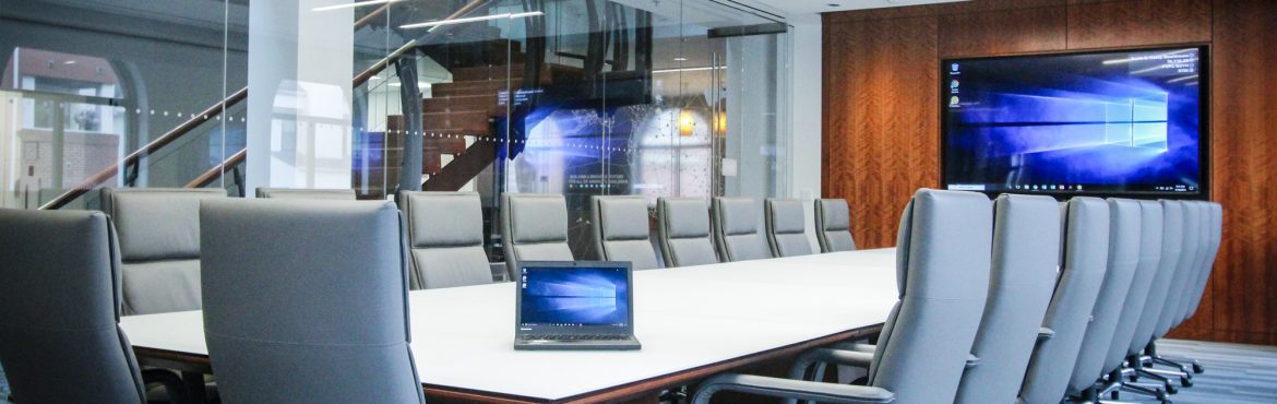 Cenero Non-Profit Boardroom. A large meeting table with chairs all around and a large tv screen at the end of the room.