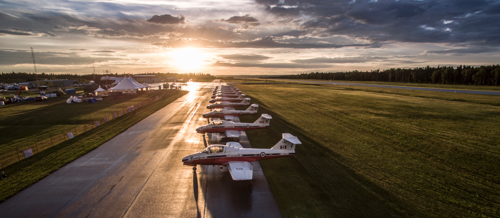 Moose Jaw Saskatchewan photo of Snowbirds airplanes on the runway with the sun setting behind them.