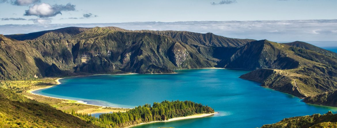 Maountains and ocean with clouds behind.