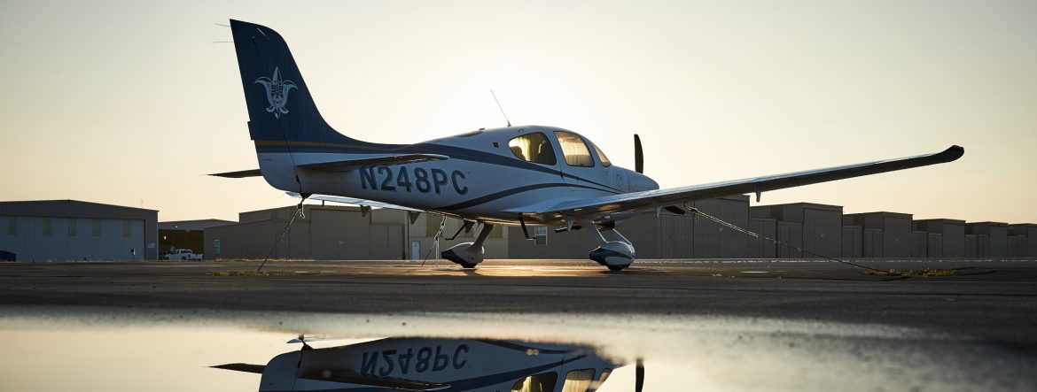 St. Louis Downtown Airport plane on the runway with a reflection in water runoff below it.