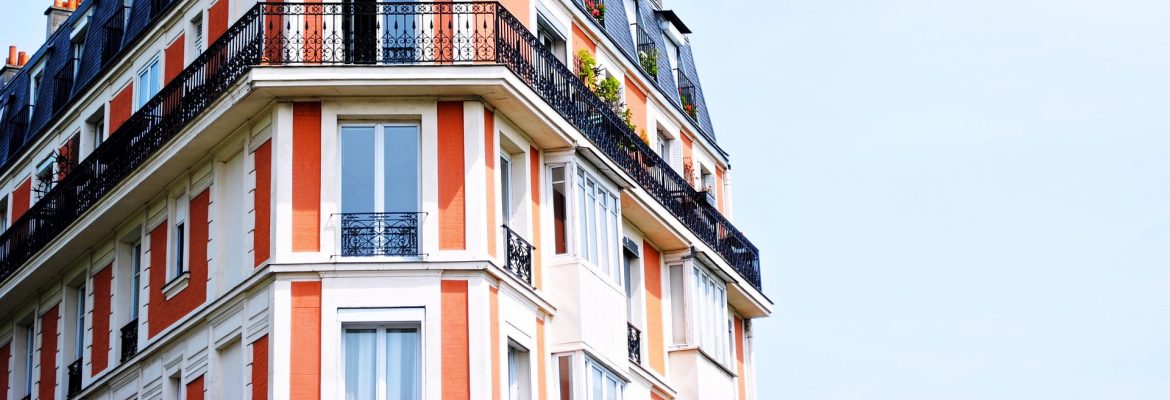 The National Association of Residential Property Managers. The top of a residential building showing a patio and windows with a blue sky.