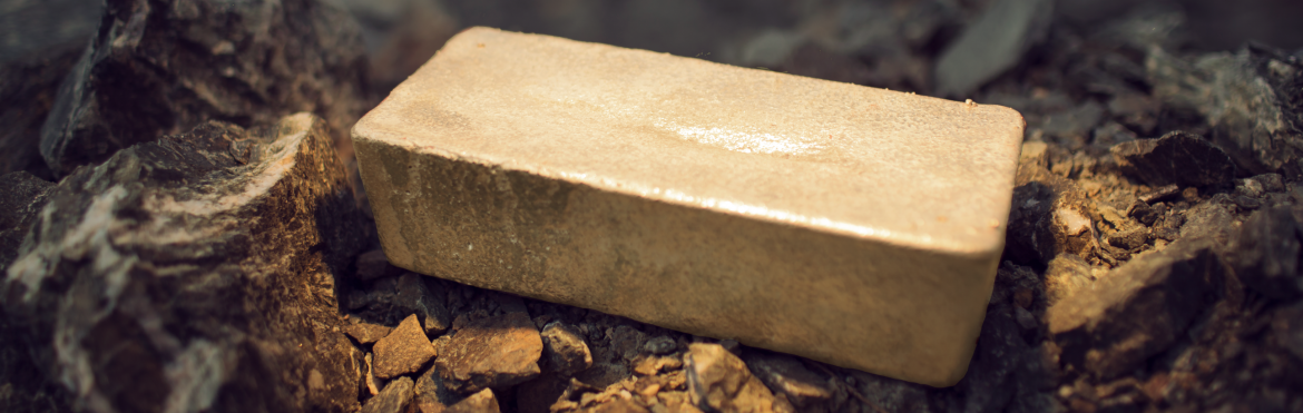 Anaconda Mining. Gold bar laying on a rock.