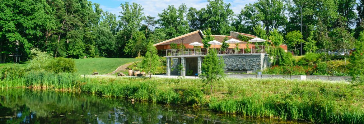 The Maryland Green Registry. A building sits surrounded by woods and a pond in the foreground.