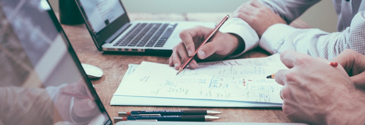 Great Resumes Fast Executive Writing Tips for 2019. Two people sitting at a table with laptops and pen and paper.