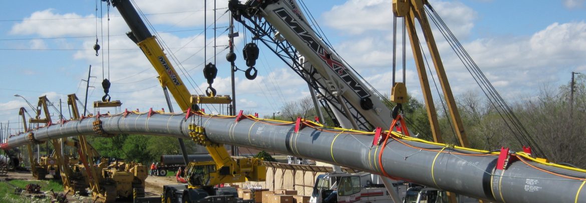 Arceneaux Wilson & Cole LLC. A long pipe being installed with multiple cranes holding it up in the air.