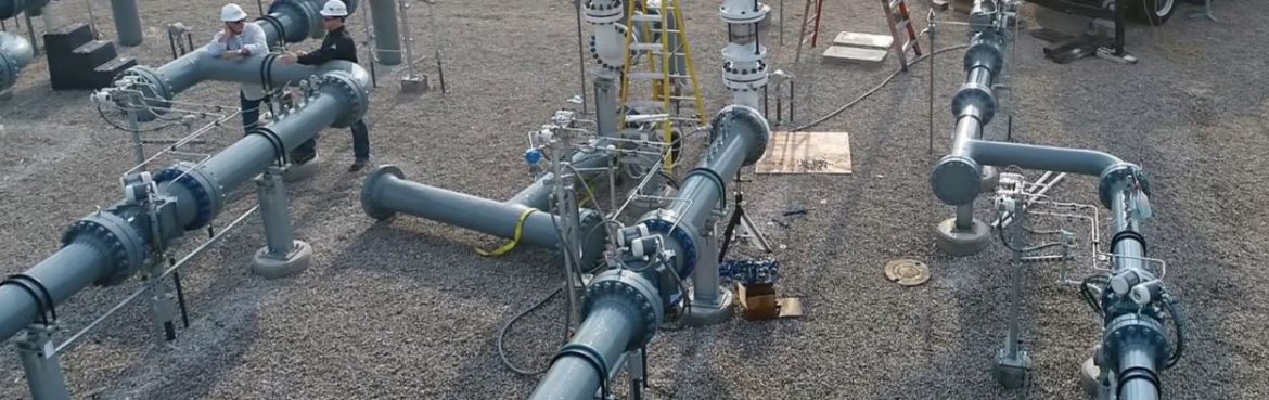 Big Elk Energy pipes over gravel with workers.