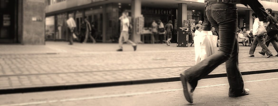 Flexible Packaging Association. A person walking on a busy city street with a plastic bag.