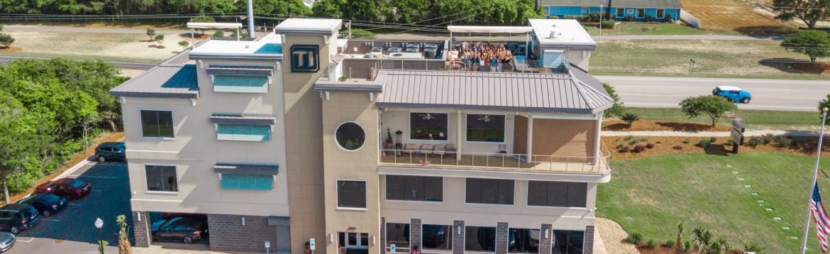 Transportation Impact aerial view of building with people standing on the roof cheering.