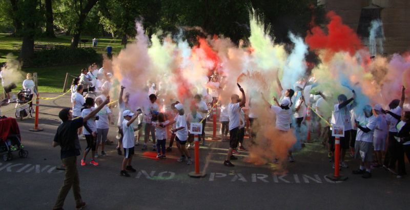 Riverbank, California color run recreation activity. Showing a group of people with poofs of colored powder all around everyone.