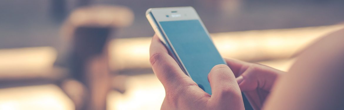 A person holding a cell phone in front of them using it. New Study Finds Millennials Concerned About Privacy, But Lax On Security