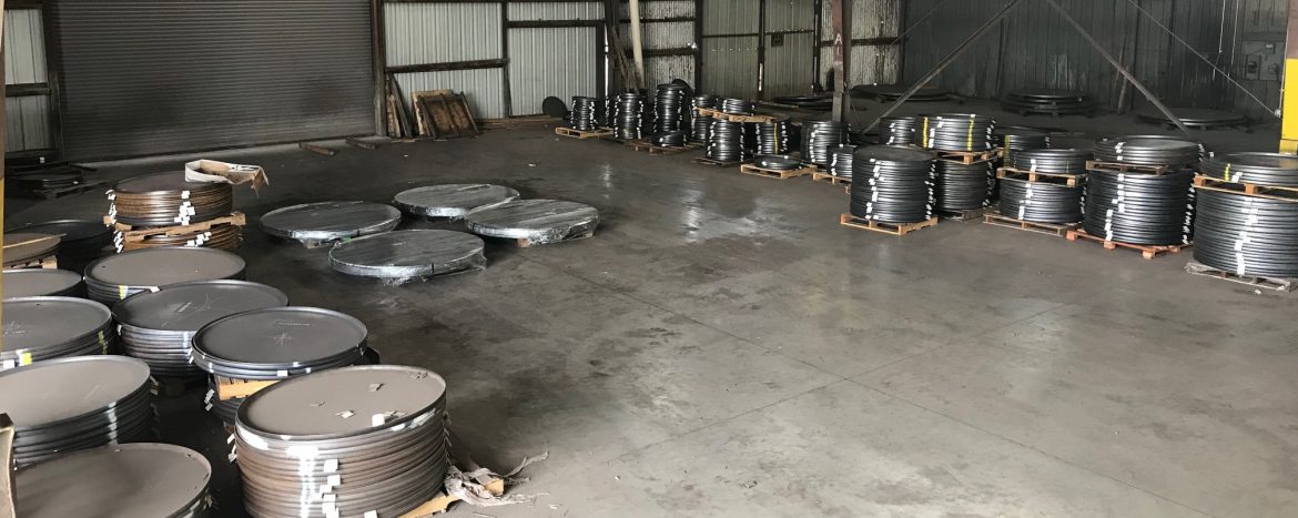 Shamrock Steel floor of warehouse with stacks of round steel parts.