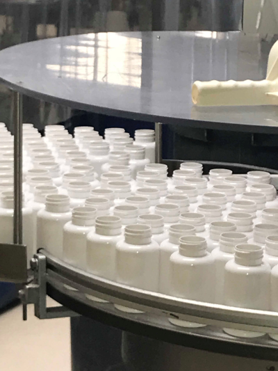 Columbia Nutritional bottles on a bottling machine.