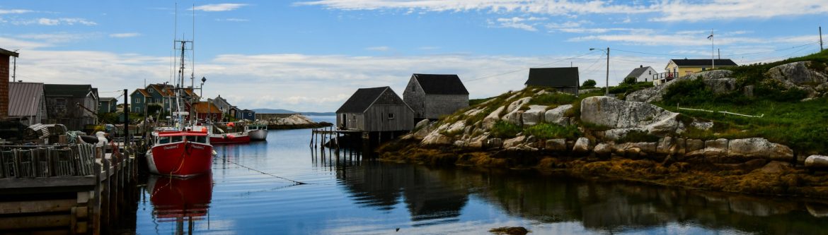 Louisbourg Seafoods, Limited. View of a bay with buildings, boats and docks.
