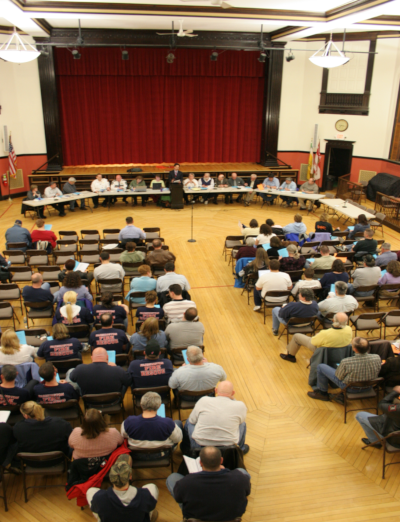 A group of people having a town meeting for Farmington New Hampshire in 2007.