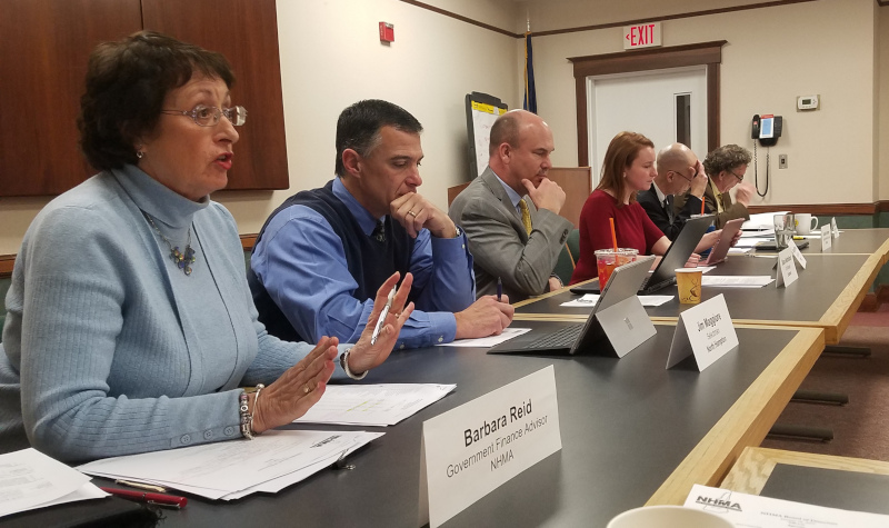 New Hampshire Municipal Association Senior staff and Board members at a meeting sitting at tables with their names on nameplates.
