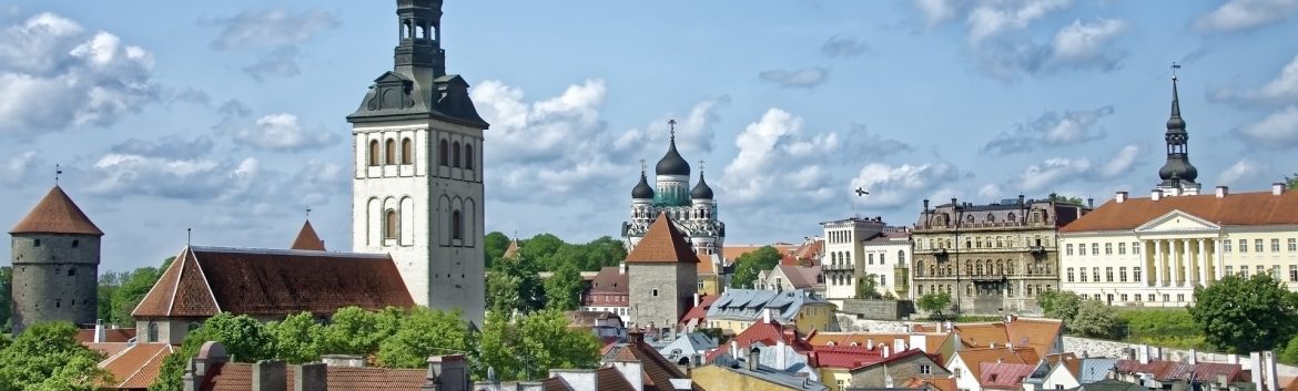 Tallin Estonia, broad view of the city showing buildings and rooftops with clouds in the sky. Unique Vacation Locations For Luxury Travelers,