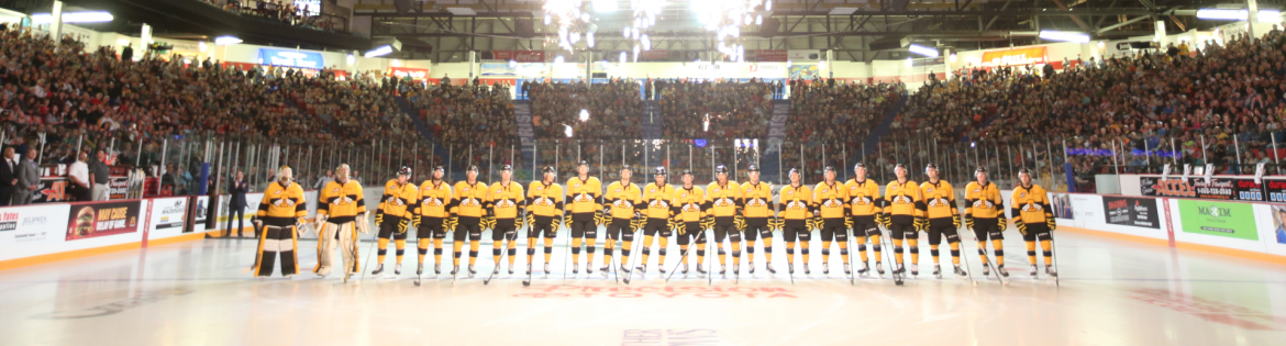 Keystone Centre Ice Hockey team lined up on the ice with fireworks going off above.