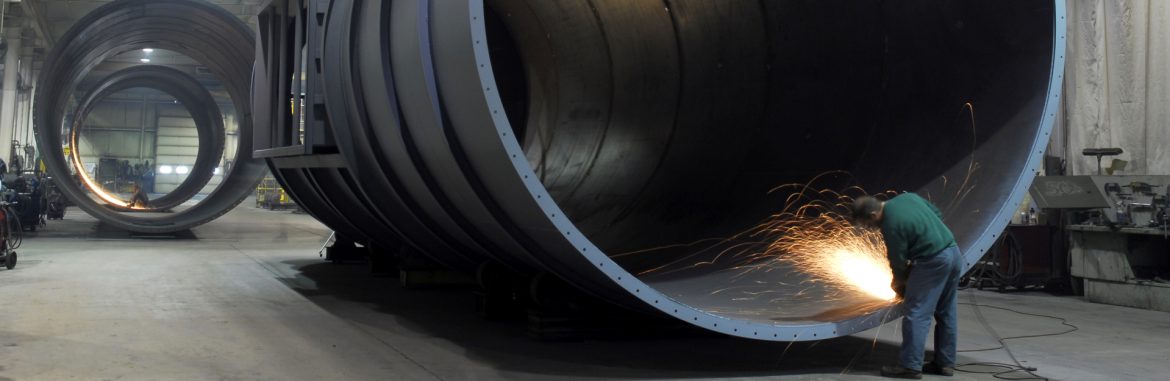 PWC Fabrication employee working on a 16 foot diameter duct with sparks flying.