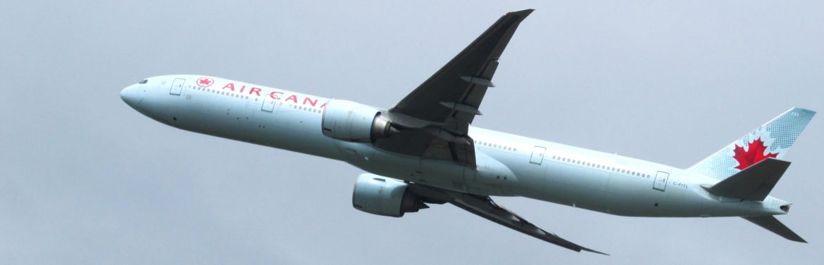 Air Canada commercial jet flying in the sky.