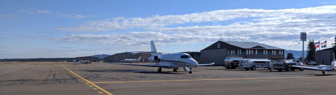 Coeur d’Alene Airport (Pappy Boyington Field) showing a small jet on the tarmac with the airfield building behind it and blue sky.
