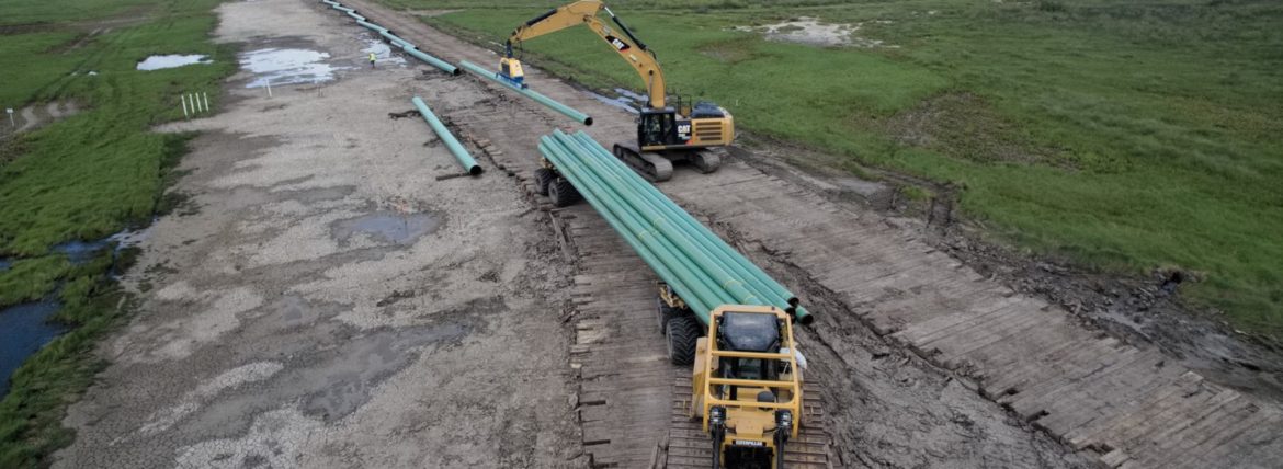 Sunbelt Equipment Marketing Semi and Excavator on a dirt road.