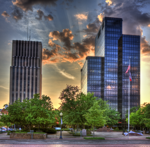Tyler, Texas sky scraped with sun rays behind the clouds.