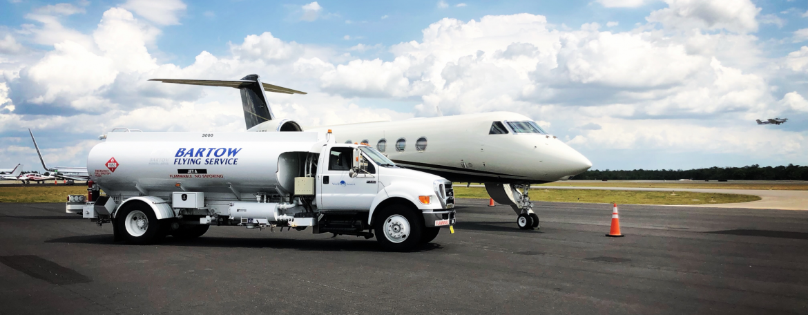 Bartow Executive Airport runway with service truck and an airplane.