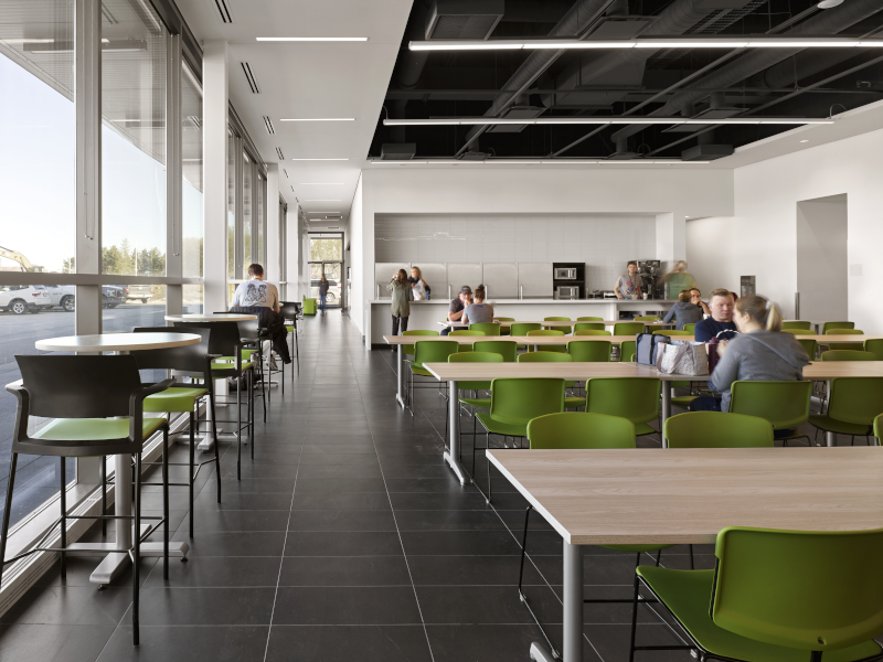 SvN Architects & Planners Inc. interior view of large space with tables, chairs and people.