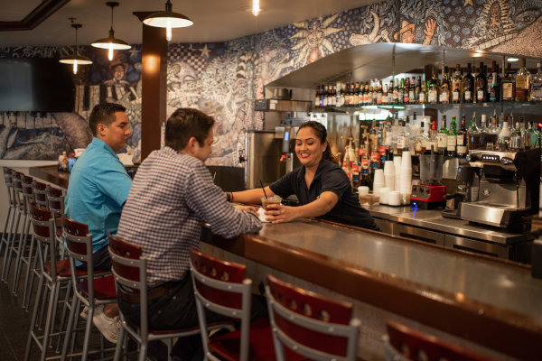 Valley International Airport, interior view of a bartender serving drinks to two men sitting.