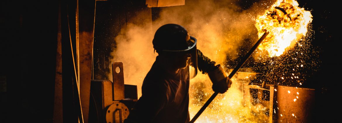 The Buck Company, employee hold a long pole with glowing molten materials on the end.