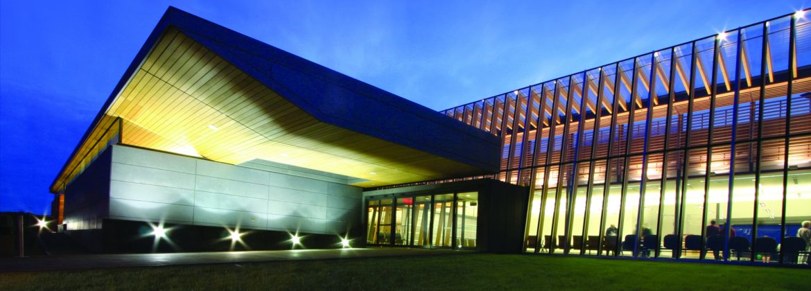Prince George International Airport Main Entrance at dusk with lights on.
