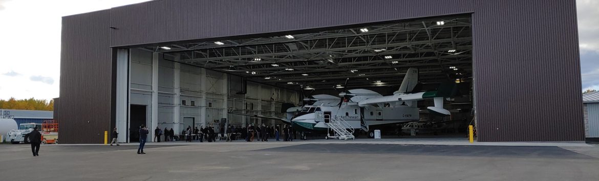 Barber Field Airport, La Ronge Airport hangar with door open and a plane with people inside.